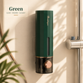 Wall soap dispenser, green with vertical slot and bronze round dispense button on wall.