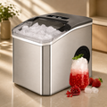 Silver-gray countertop ice maker with open top holding clear ice cubes